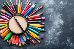 Colorful pencils and brushes arranged in a circle photo