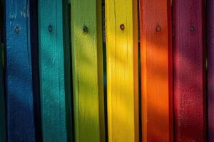 A rainbow colored fence with many different colored posts photo