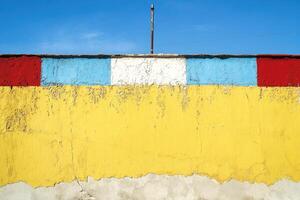 A yellow wall with a red, blue, and white stripe photo