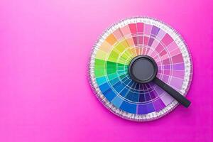 Color wheel with a magnifying glass on a pink background photo