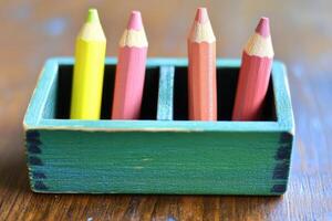 A wooden box with four colored pencils in it photo