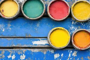 Colorful paint cans on a blue background photo