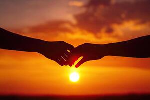 Two hands clasped at sunset photo