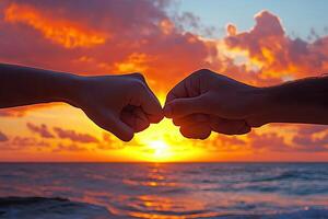 Two people holding hands at sunset photo