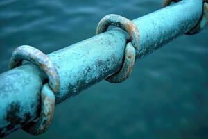 A teal-colored metal pipe with rusted rings photo