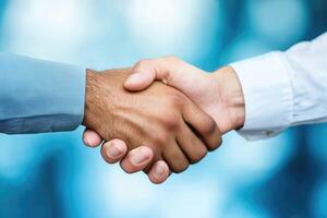 Two people shaking hands over a blue background photo