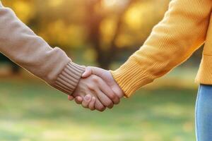 Couple holding hands in autumn park photo
