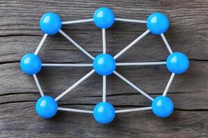 Blue spheres arranged in a network on a wooden table photo