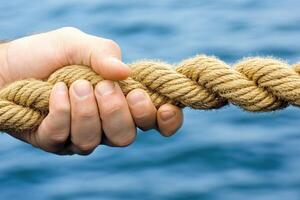 Tug-of-war, hands gripping rope photo