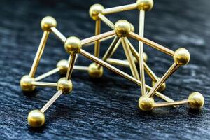 Gold ball and stick model on dark slate photo