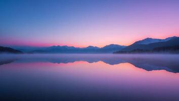 Calm Lake Reflecting Mountains at Dawn with Colorful Sky and Fog photo