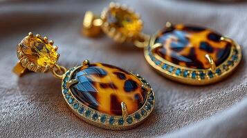 Elegant earrings with golden accents and vibrant yellow stones displayed on a soft fabric background photo