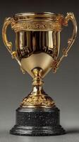 Shiny golden trophy with ornate design displayed on a dark pedestal against a black background photo