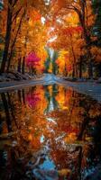 Vibrant autumn colors reflect in a puddle along a winding road in the forest photo