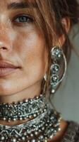 Close-up of a woman showcasing intricate silver jewelry with a natural makeup look in soft lighting photo