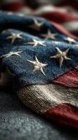 Tattered United States flag with stitched stars draped over a rough surface showing pride and history photo