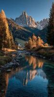 Stunning autumn landscape with mountains and reflection in tranquil river near an alpine village at sunset photo