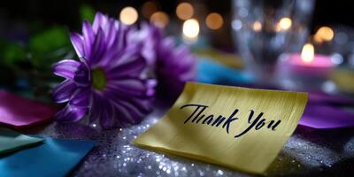 Colorful thank you note surrounded by flowers and candles at a festive gathering in the evening photo