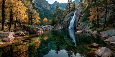 Waterfall cascading into serene pool surrounded by autumn foliage in mountainous forest photo