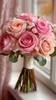 Beautiful bouquet of pink and peach roses arranged elegantly near a window on a bright day photo
