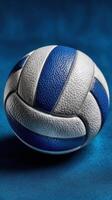 Detailed close-up of a blue and white volleyball resting on a textured surface with a smooth finish photo