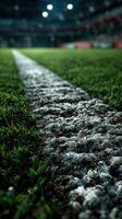Grass and white line on a soccer field during evening time with stadium lights illuminating the area photo