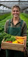 Smiling farmer holds fresh vegetables in a greenhouse during harvest time photo