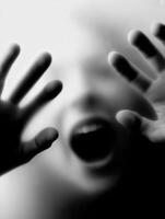 Frightened child reaching out with hands in a blurred background photo