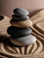 Balanced stones stacked artfully on textured sand background at tranquil setting photo