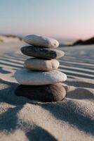 Stacked stones create a tranquil moment on sandy beach at sunset photo