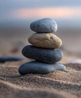 Stones delicately balanced on sandy beach at twilight photo