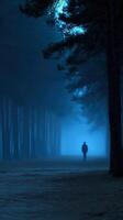 A man walking through a foggy forest at night photo