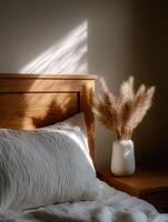 Soft light casts delicate shadows on serene bedroom decor with pampas grass photo