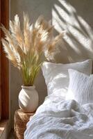 Cozy bedroom corner with soft pillows and decorative plant in sunlight photo