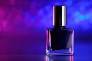 Dark blue nail polish bottle illuminated by colorful lights in a studio photo
