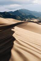 Sand dunes and mountains under soft sunlight in a desert landscape photo