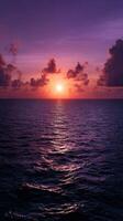 Sunset over ocean with colorful clouds and gentle waves in serene evening photo