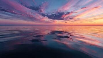 Colorful sunset over calm ocean waters with reflective clouds photo
