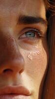 Close-up shows Woman with bright Eyes and Tears on her Cheeks photo