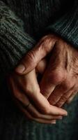 Hands interlocked, wearing a gray sweater inside photo