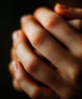 Hands clasped together in prayer, close up view with dark background photo