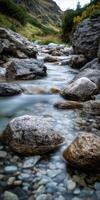 Flowing stream over rocks through scenic Mountain Valley during daytime photo