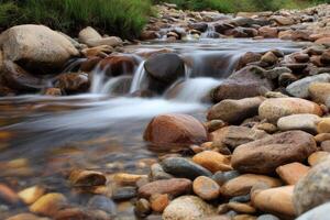 Water flows over rocks in stream at daytime photo