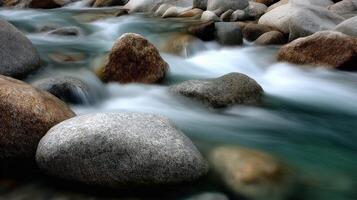 Water flows among smooth rocks and boulders in a river photo