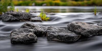 Rocks in a river with blurred water effect photo