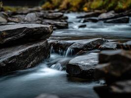 Water cascades over rocks in a river, long exposure photo