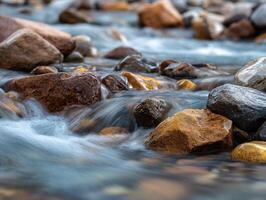 Mountain stream flows around rocks at daytime in Summer photo