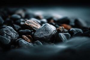 Dark wet pebbles and small rocks on a beach at dusk photo