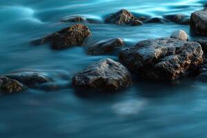 Water flows among large coastal rocks on the shore at sunset photo