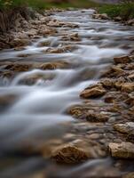 Mountain stream flows between rocks in a peaceful landscape photo